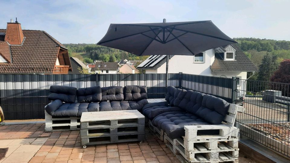 Palettelounge mit Kissen und Schirm in Weinbach