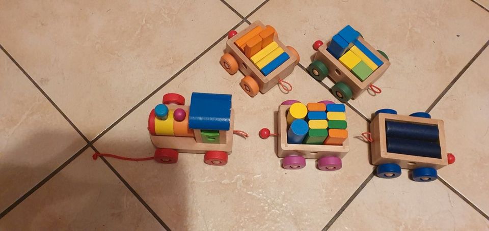 Holzspielzeug, Holzeisenbahn bunt mit vielen Klötzern zum beladen in Schollene