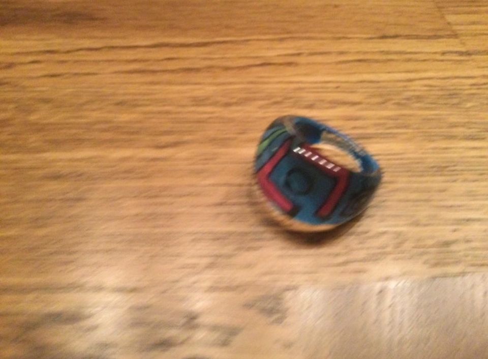 Blau farbener Ring aus Kunststoff mit rot-grünen Verzierungen in Nickenich