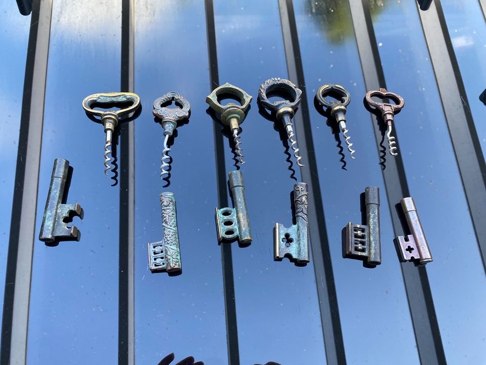 Verschiedene Korkenzieher Schlüssel aus Metall mit Regal in Laer