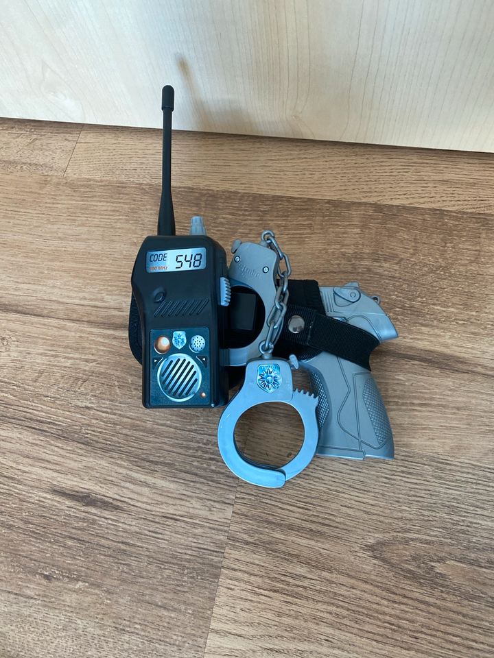 Polizeipistole mit Handschellen und Funkgerät in Zeulenroda