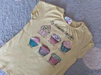 Gr. 104/110 Topolino T-Shirt hellgelb Muffins Cupcakes Nordrhein-Westfalen - Ratingen Vorschau