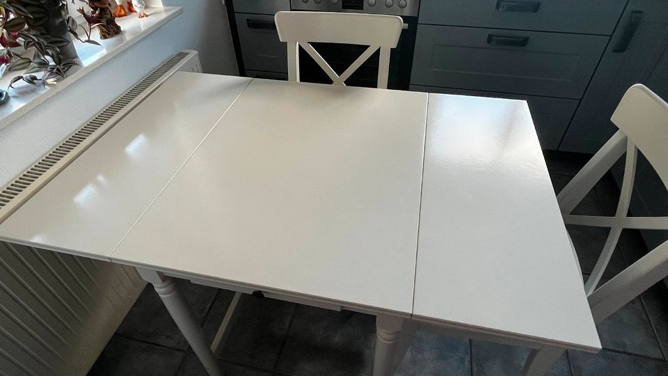 Weißer Küchentisch mit Schublade und 2 Stühle mit Kissen in Grömitz