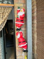 zwei an einem Lichtschlauch hoch kletternde Weihnachtsmänner Niedersachsen - Braunschweig Vorschau