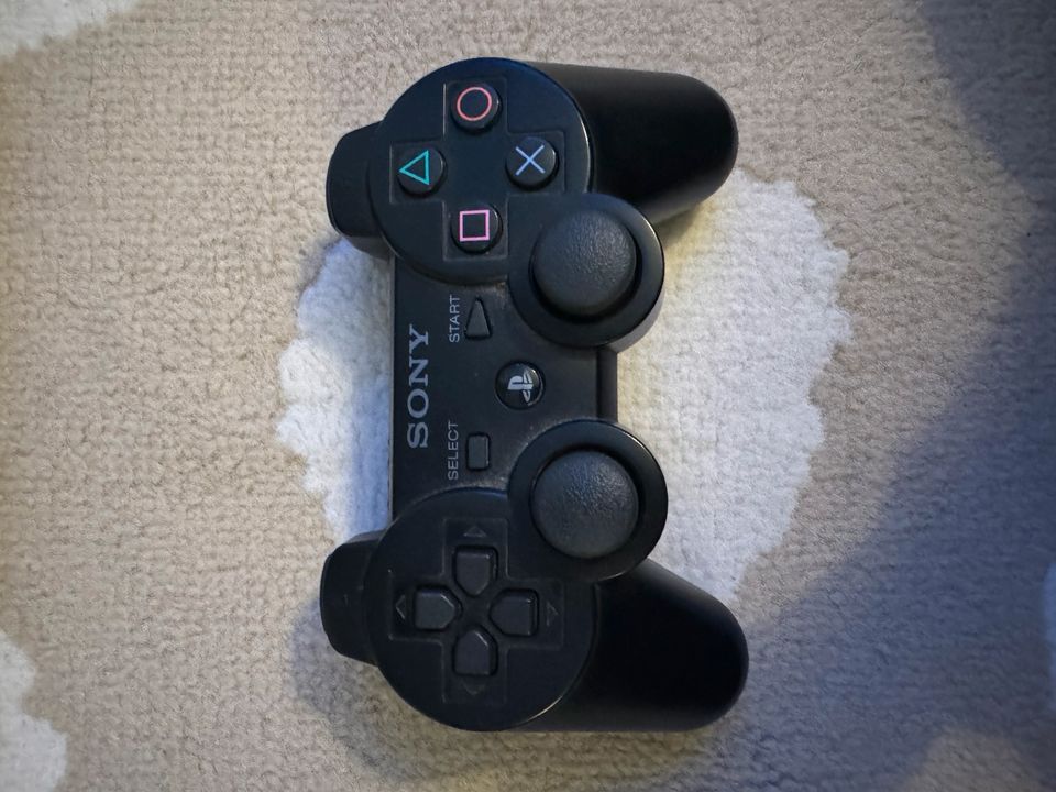 PlayStation 3 mit Controller und Spielen in Moers