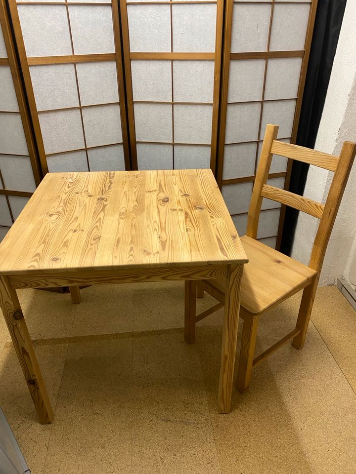 Holztisch mit Stuhl in Steinen