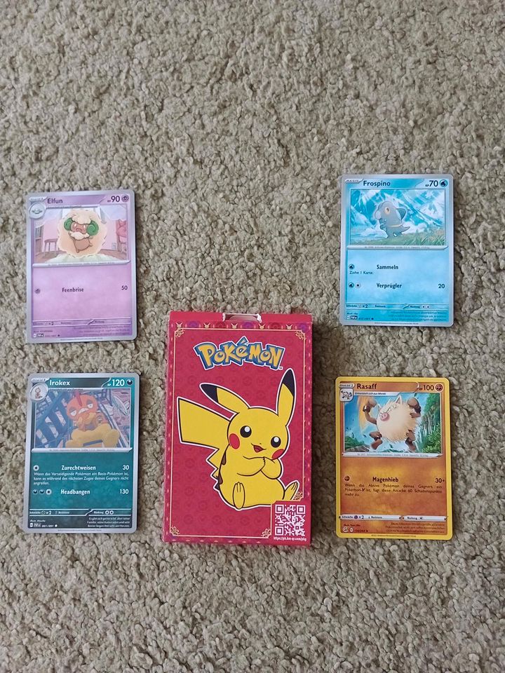 vier Pokémonkarten in einer kleinen Box in Berlin