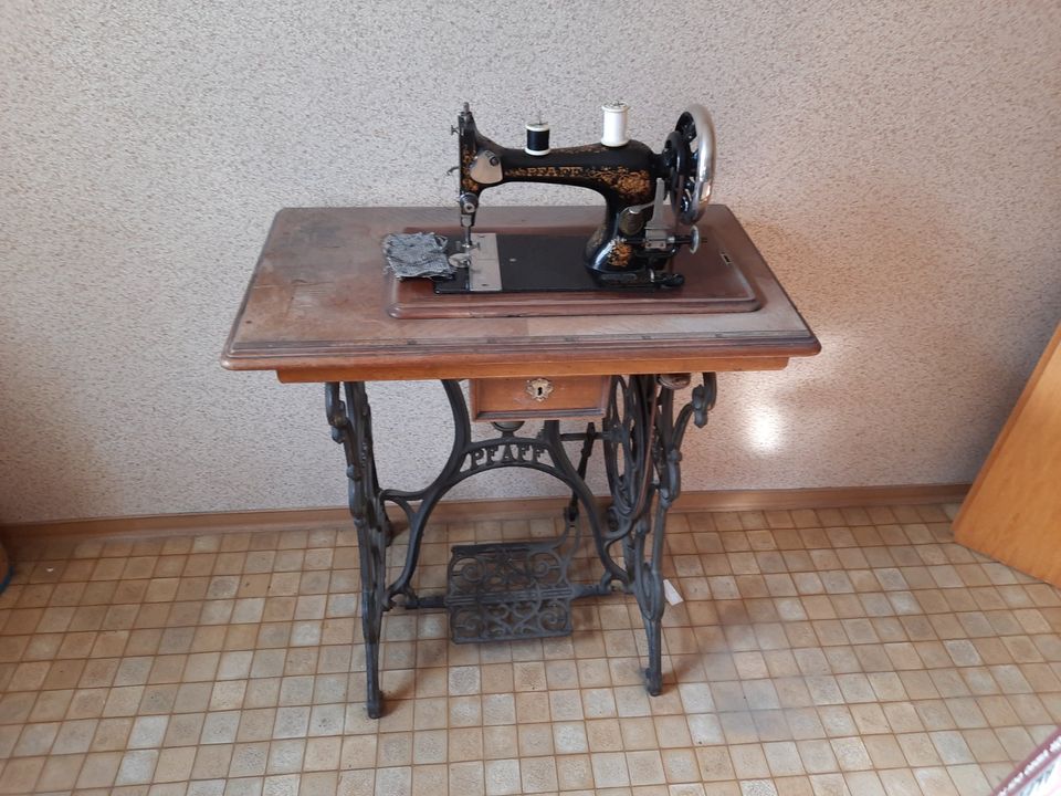 alte PFAFF Nähmaschine mit Gussuntergestell und ein Spinrad in Neustetten