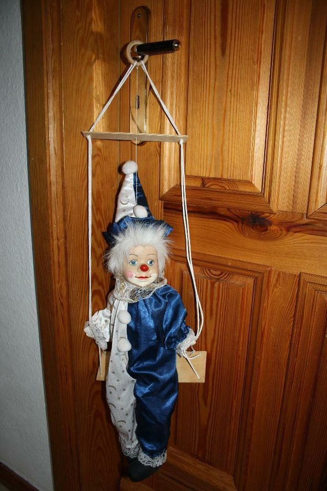 Clown, Harlekin, Marionette, 60 cm lang, sitzt auf Schaukel in Arnstein