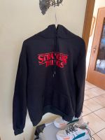 Hoodie-Pullover, schwarz, mit Schriftzug „Stranger Things“ Nordrhein-Westfalen - Verl Vorschau