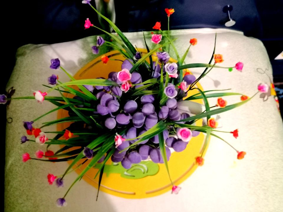 Osterdeko: Pflanzgefäße Schwan mit kleinen lila Eiern und Blumen in Raunheim