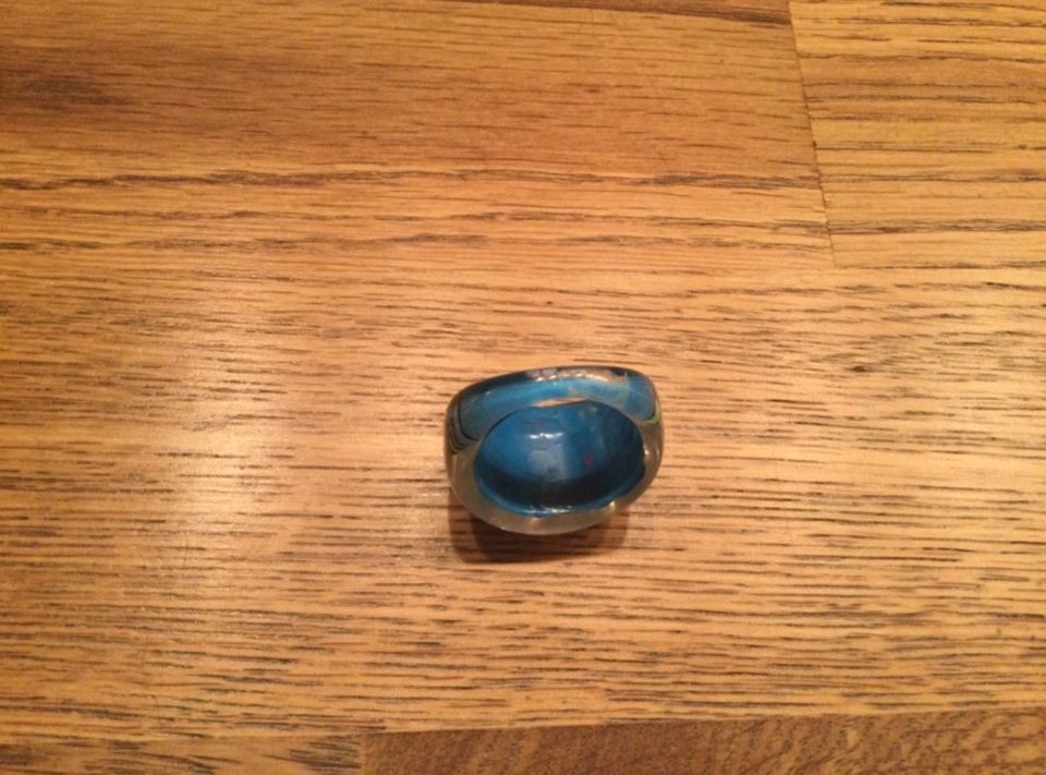 Blau farbener Ring aus Kunststoff mit rot-grünen Verzierungen in Nickenich