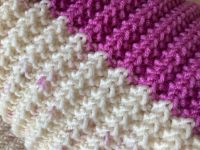 Handgestrickte pink wollweiße Babydecke Blockstreifen Merino Niedersachsen - Hankensbüttel Vorschau