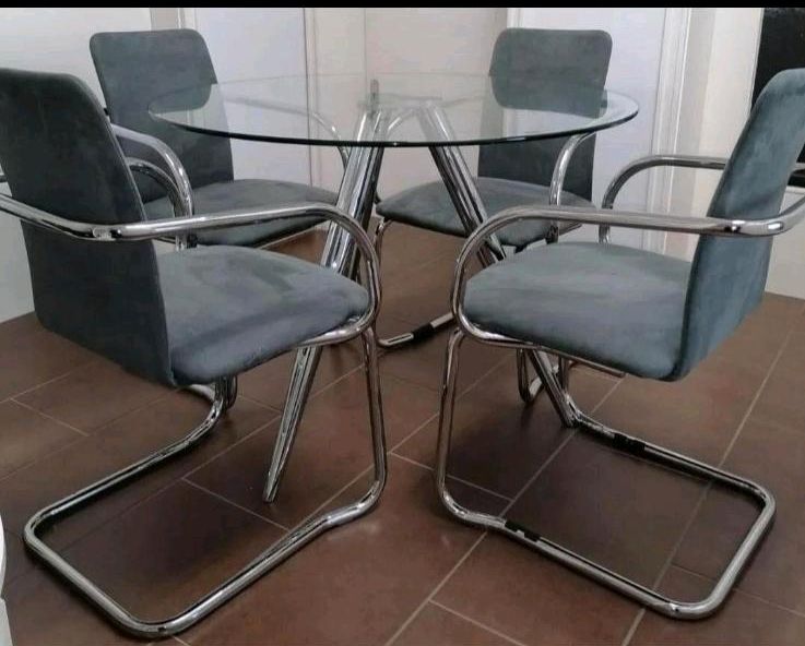 Runderglas mit vier Stühlen in München
