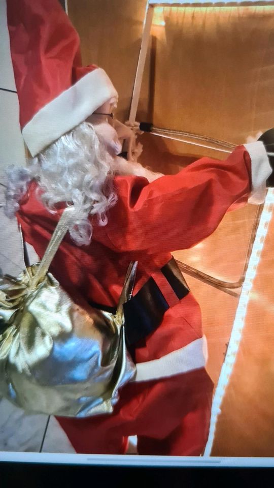 Santa Claus kletternd auf Lichtleiter in Plaidt