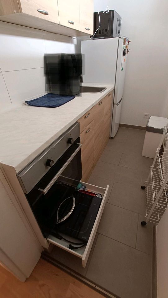 Küche mit Backofen, Mikrowelle und Kühlschrank. in München