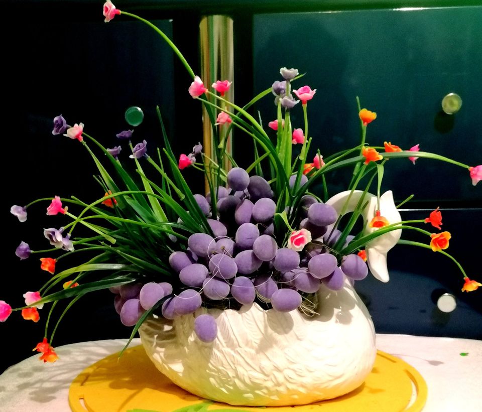Osterdeko: Pflanzgefäße Schwan mit kleinen lila Eiern und Blumen in Raunheim