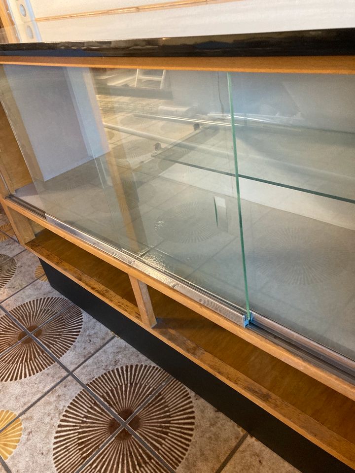Vitrine aus Holz mit Schiebetüren aus Glas in Weinheim