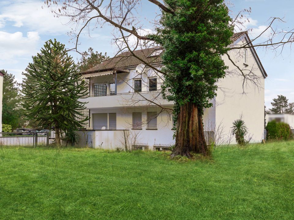 Ein großes Mehrfamilienhaus mit angrenzendem Baugrundstück und einem ausgedehnten Gartenbereich. in Karlsruhe